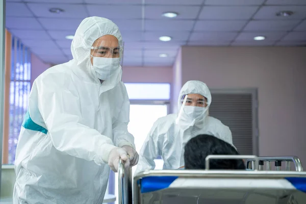 Doctor wear mask and ppe uniform medical protect covid-19 corona virus disease with wheelchair at hospital.