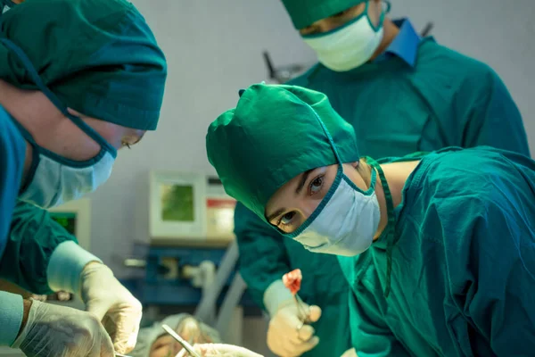 Doctors with surgery team operating in a surgical room at hospital.