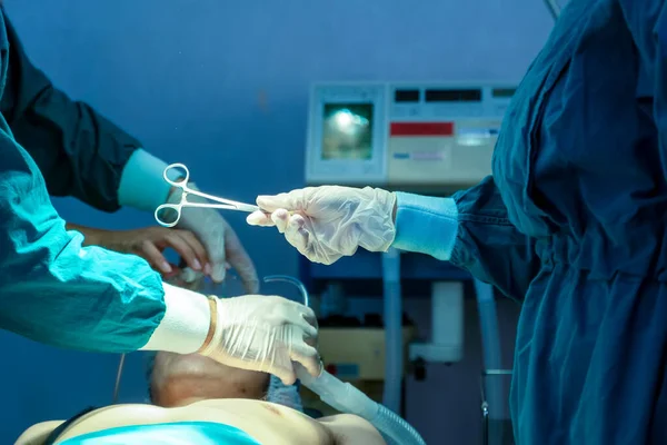 Doctors with surgery team operating in a surgical room at hospital.