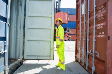 Konteynır işçisi konteynır kutusunu kontrol ederek limanda lojistik ihracat ve içeri aktarma. 