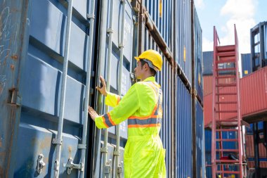 Lojistik ihracat ve ithalat için lojistik nakliye konteynırlarında çalışan Asyalı ustabaşı konteyner kutusunu kontrol ediyor..