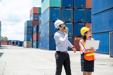 İş adamı ve sekreteri konteynır kargo, lojistik ağı konsepti sanayiinde online aygıtı denetliyor..