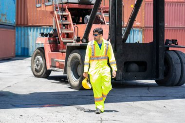 Limandaki konteynır deposundaki iş süreçlerini kontrol eden ciddi liman işçisi.