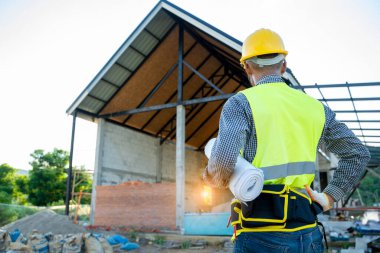 İnşaat alanının planlarıyla çalışan bir mühendis.