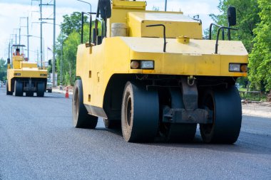 Şehirdeki yeni yol inşaatında çalışan yol silindirleri.