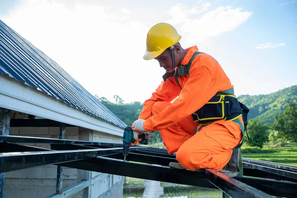 プロの技術労働者は 金属シートと新しい屋根に使用される新しい屋根 屋根のツール 電気ドリルをインストールします — ストック写真