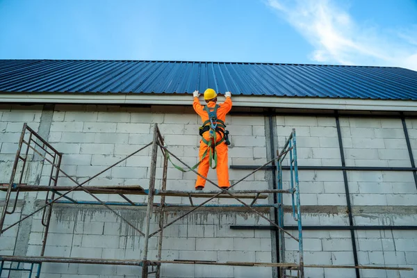 建筑工人在建筑工地进行屋面结构施工时 在高度设备上佩戴安全带 — 图库照片