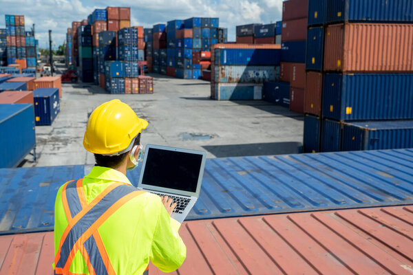 Инженер в защитной форме комбинезон безопасности использовать ноутбук компьютер проверки продукта на складе грузовых контейнеров доставки. 
