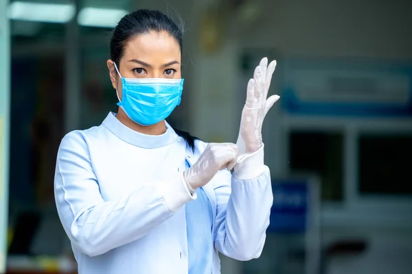 外科用マスクを持つ女性医師は外科用手袋を着用し 病院で働く準備をしています コロナウイルスの概念に対する保護 — ストック写真