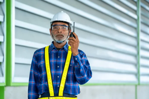 Engenheiro Usando Walkie Talkie Enquanto Colegas Discutindo Armazém — Fotografia de Stock