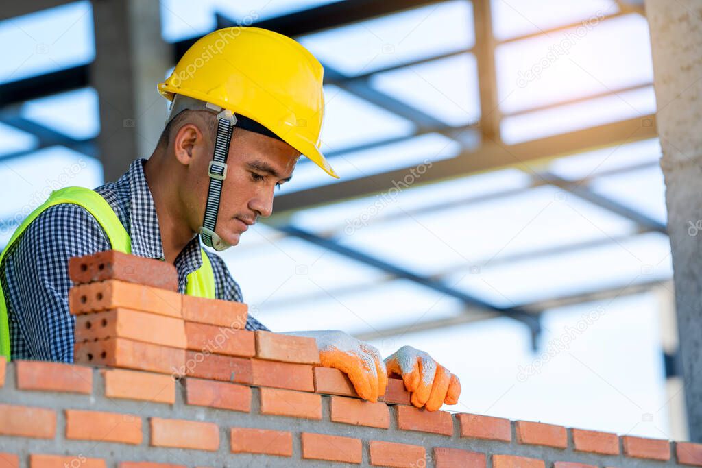  Construction Worker installing bricks on construction site.
