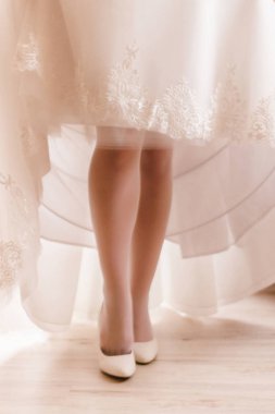 Gelin elbisesini yükseltir. Güzel bacaklar ve gelinlik görülebilir