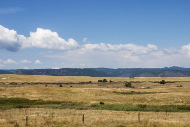 Doğal dağlar, yaz güneşli bir günde derin gökyüzü beyaz bulutlar ile temizleyin. Dağlar eteğinde küçük Amerikan kentlerinin bulunduğu evler. Colorado, ABD.