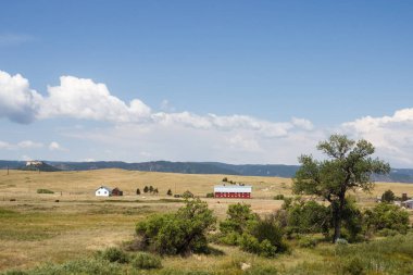 Doğal dağlar, yaz güneşli bir günde derin gökyüzü beyaz bulutlar ile temizleyin. Dağlar eteğinde küçük Amerikan kentlerinin bulunduğu evler. Colorado, ABD.