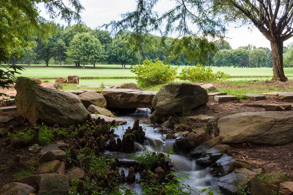 Güzel park ile taşlar ile küçük bir nehir. Bir dere kıyısında taşlarla hızla ormanda çalışıyor. Çevre düzenlemesi. Park Milliken Botanik Bahçesi, Spartanburg, Güney Karolina, ABD