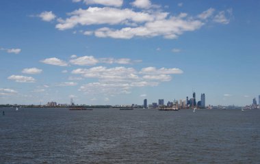 Ufukta New York gökdelenleri görülüyor. New York gökdelenleri uzakta. Bay, mavi gökyüzü, New York'ta güneşli yaz günü.