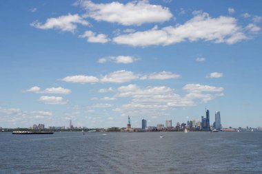 Ufukta New York gökdelenleri görülüyor. New York gökdelenleri uzakta. Bay, mavi gökyüzü, New York'ta güneşli yaz günü.