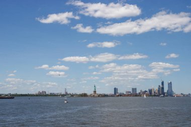 Ufukta New York gökdelenleri görülüyor. New York gökdelenleri uzakta. Bay, mavi gökyüzü, New York'ta güneşli yaz günü.