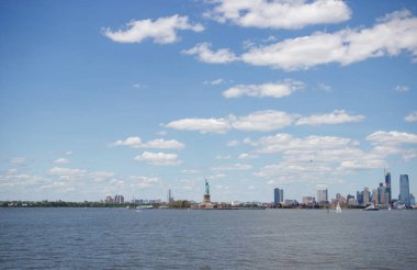 Ufukta New York gökdelenleri görülüyor. New York gökdelenleri uzakta. Bay, mavi gökyüzü, New York'ta güneşli yaz günü.