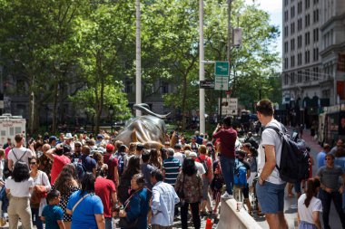 Wall Street'teki Charging Bull heykelinin etrafında çok sayıda turist toplanıyor. New York, Manhattan, Broadway.