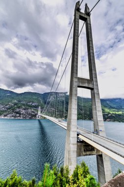 A truck makes its way across the Hardanger Bridge in Norway, connecting the municipalities of Ullensvang and Ulvik, providing a vital transportation link across the Hardangerfjord.