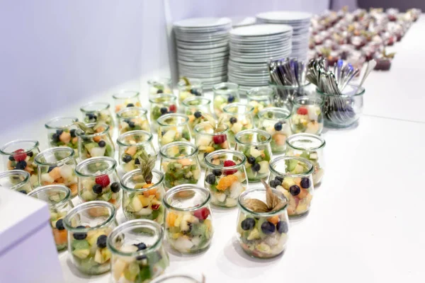 Closeup many dessert jar rowed up on buffet table with fresh fruits jelly and cream — Stock Photo, Image