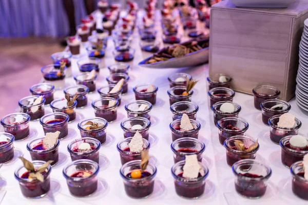 Closeup many dessert jar rowed up on buffet table with fresh fruits jelly and cream — Stock Photo, Image