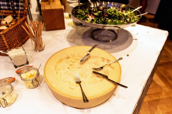 Gran rueda de queso parmesano en el mostrador de la mesa de autoservicio del restaurante con cuchillo y tenedor —  Fotos de Stock