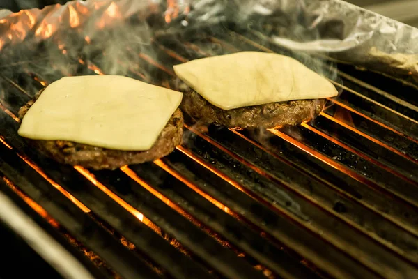 hamburger beef patty grilled meat and cheese on a barbecue grill fire