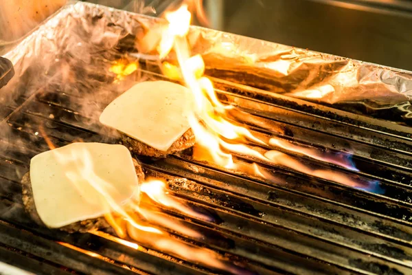 Hamburger rundvlees patty gegrilde vlees en kaas op een barbecue grill brand — Stockfoto