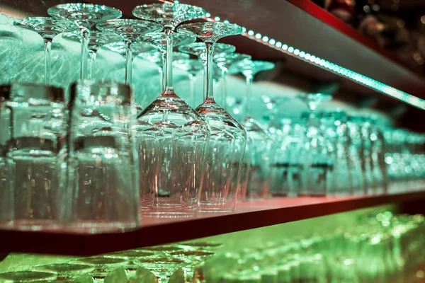 Vetro di cristallo, fila e pila di diversi scaffali di vetro dietro il bancone del bar, e pronto all'uso — Foto Stock