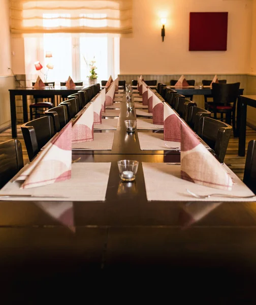Petit plat blanc et bol sur une longue table en bois préparer pour le dîner restaurant de soirée — Photo