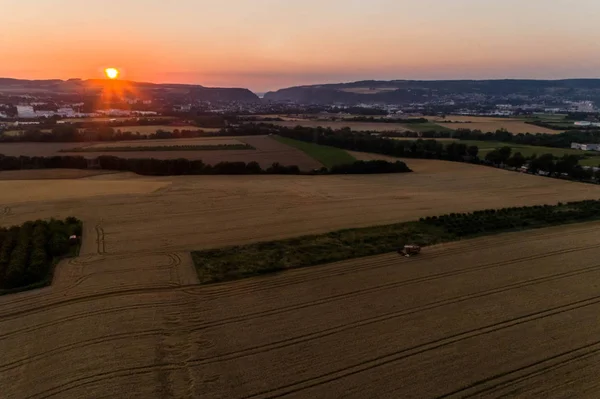 Aerial view of combine harvester harvesting an oats crop at sunset — Stock Photo, Image