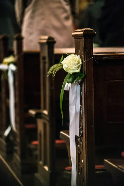 Vacker blomma bröllop dekoration i en kyrka hänga på sätet raderna i kapellet, ceremoni selektivt fokus — Stockfoto