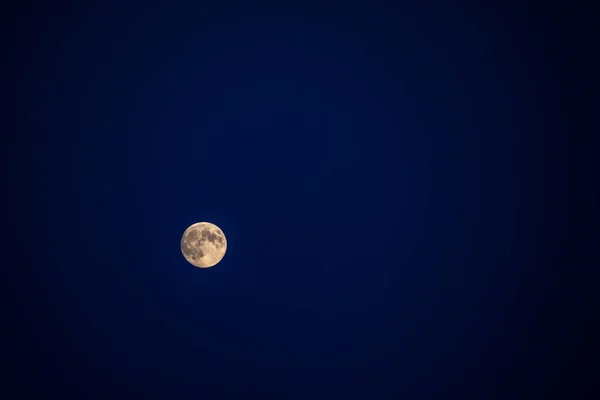 Lua grande em sua fase completa com crateras detalhadas visíveis em suas bordas, tudo em um fundo preto — Fotografia de Stock