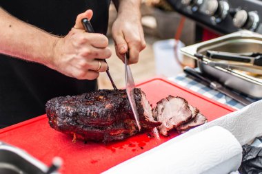 Şef aşçı füme kesme sığır eti, mutfak masasının üstünde domuz eti kesme kasap