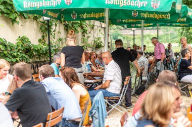 Koblenz Germany -28.07.2018 Picture of people sitting in a typical German koenigsbacher beer garden in the town Koblenz clipart