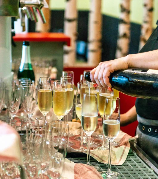 Barman derramando champanhe ou vinho espumante em vidro, close-up em copos no restaurante — Fotografia de Stock