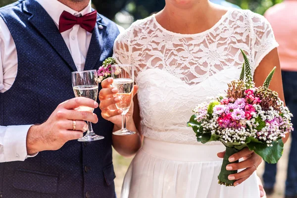 シャンペーンのスパーク リング ワインの乾杯で結婚式のメガネを持って美しく新郎新婦 — ストック写真