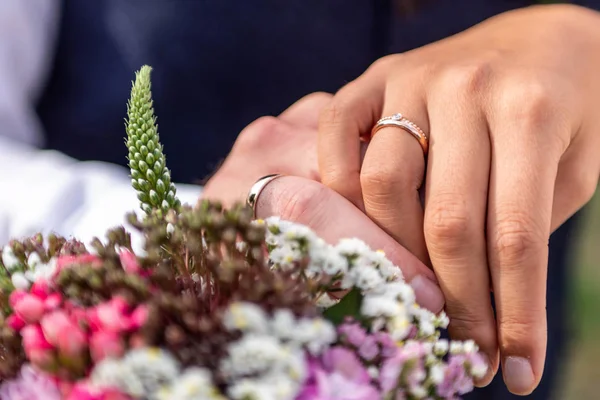 Handen van bruid en bruidegom met trouwringen en bloemen boeket viering liefde symbool — Stockfoto