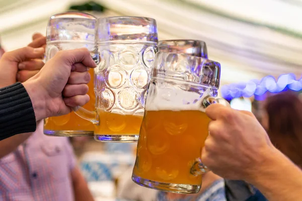 Un grupo de jóvenes Amigos brindando con vasos de cerveza en el Oktoberfest germany Soft focus. DOF poco profundo — Foto de Stock