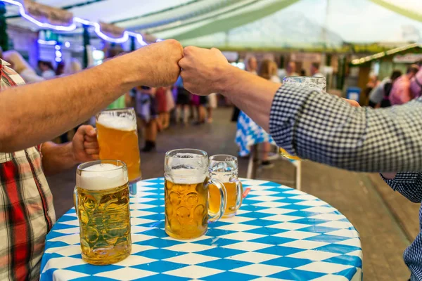 Un groupe de jeunes Amis griller avec des verres de bière à l'Oktoberfest germany Soft focus. DOF peu profond — Photo