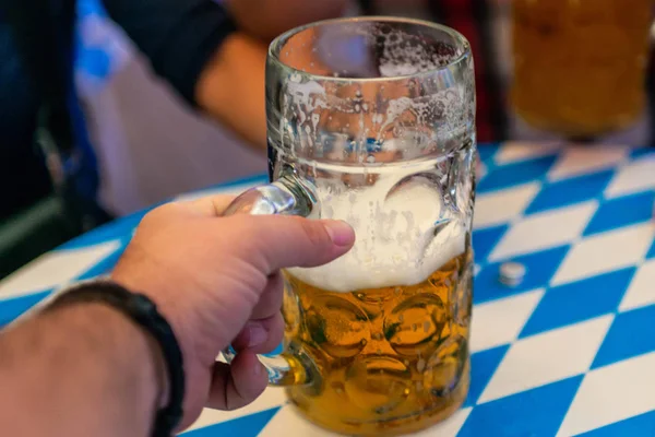 Στο χέρι των νέων άρση ποτήρια μπύρας το Oktoberfest Γερμανία απαλή εστίαση. Ρηχά Dof — Φωτογραφία Αρχείου