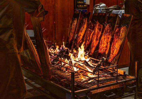 Delicious flamed Salmon is smoked on open fire at Christmas market — Stock Image Delicious flamed Salmon is smoked on open fire at Christmas market Stock Picture