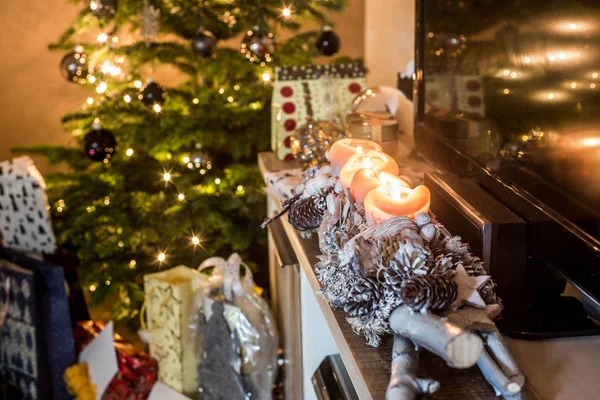 Quatro velas de advento ardentes, belas luzes de configuração decoradas na árvore de Natal de fundo com presentes — Fotografia de Stock