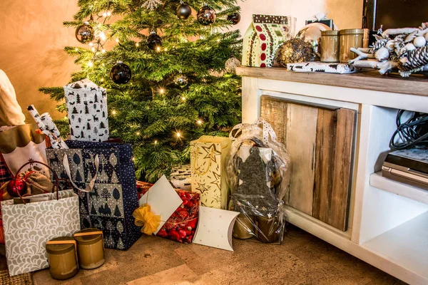 Pequenas caixas de presente artesanais em brilhante noite colorida Natal árvore configuração fundo celebração — Fotografia de Stock