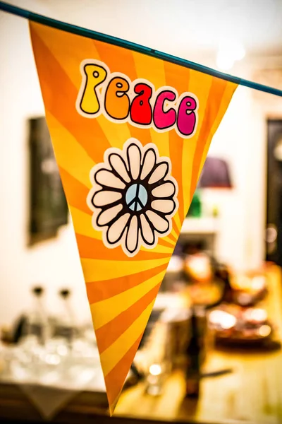 Hippie peace tekst en liefde flowerpower van op een hangende partij bord boven een onscherpe achtergrond — Stockfoto