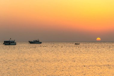 tekne silhouetts Kızıldeniz Makadi Bay Mısır altın renklerde gün batımında kıyısında