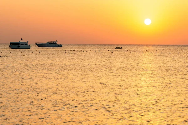 Silhouetts lodí na pobřeží Rudého moře při západu slunce v Makadi Bay Egypt zlaté barvy — Stock fotografie