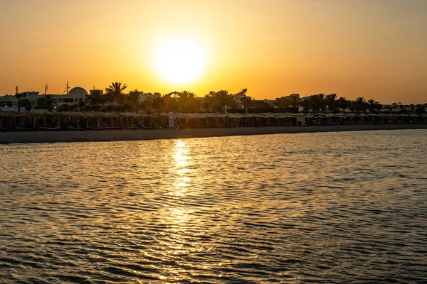 Západ slunce nad Rudé moře palm tree silhuettes hotel v Makadi Bay Egypt — Stock fotografie